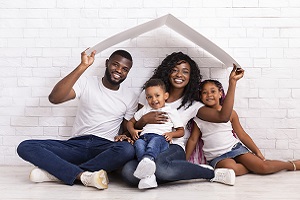 Family Holding Cardboard Roof Above Head